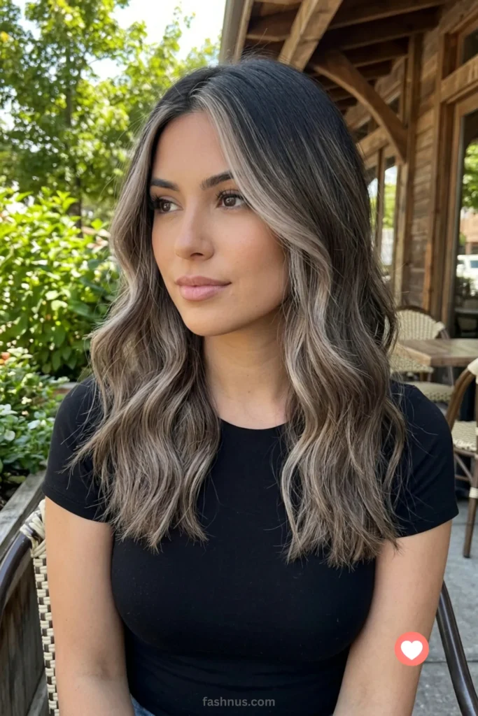 Vertical medium close-up of seamless ash brown balayage with bright, cool-toned face-framing highlights (money pieces) on long, loose waves.